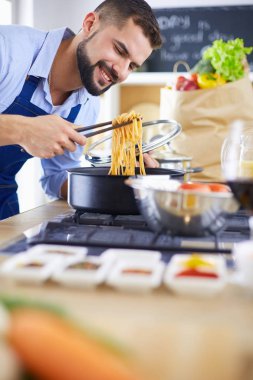 Adam ev mutfağında lezzetli ve sağlıklı yemekler hazırlıyor.