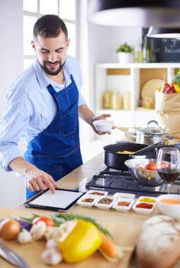 Adam ev mutfağında lezzetli ve sağlıklı yemekler hazırlıyor.