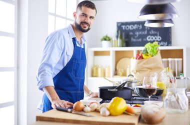 Adam ev mutfağında lezzetli ve sağlıklı yemekler hazırlıyor.