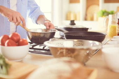 Adam ev mutfağında lezzetli ve sağlıklı yemekler hazırlıyor.