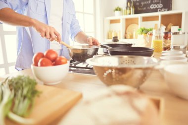 Adam ev mutfağında lezzetli ve sağlıklı yemekler hazırlıyor.