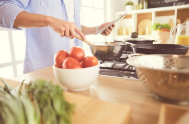 Adam ev mutfağında lezzetli ve sağlıklı yemekler hazırlıyor.