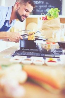 Adam ev mutfağında lezzetli ve sağlıklı yemekler hazırlıyor.