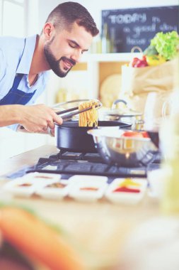 Adam ev mutfağında lezzetli ve sağlıklı yemekler hazırlıyor.
