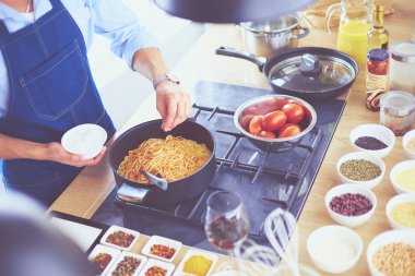 Adam ev mutfağında lezzetli ve sağlıklı yemekler hazırlıyor.