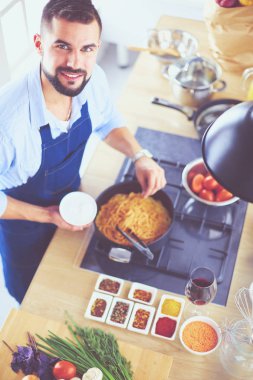 Adam ev mutfağında lezzetli ve sağlıklı yemekler hazırlıyor.