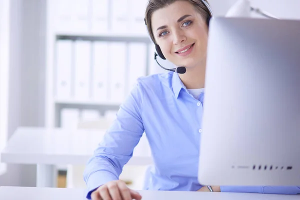 Serious pretty young woman working as support phone operator with headset in office — Stock Photo, Image