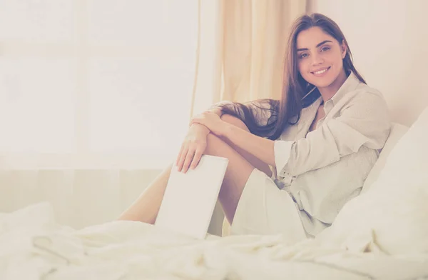 Retrato de la mujer usando tableta y tomando café mientras está sentada en la cama por la mañana —  Fotos de Stock