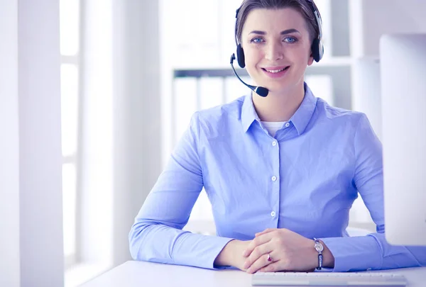 Ernstige mooie jonge vrouw die werkt als support telefoon operator met headset in het kantoor — Stockfoto