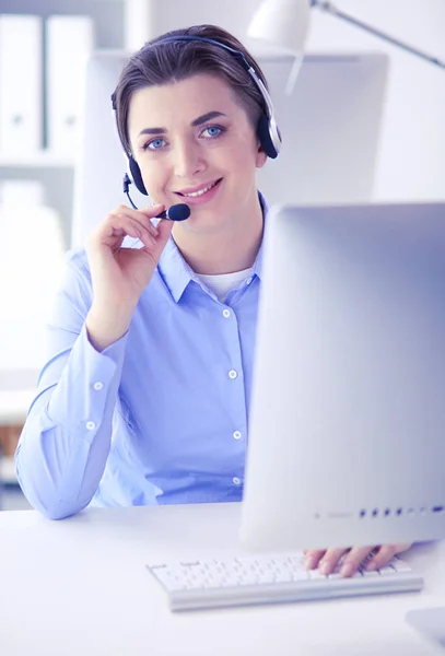 Sério muito jovem mulher trabalhando como operador de telefone de apoio com fone de ouvido no escritório — Fotografia de Stock