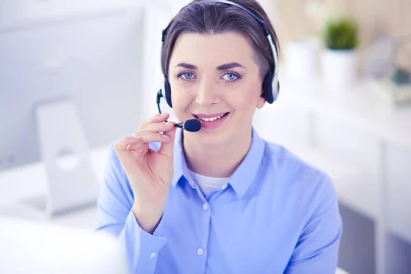 Grave bella giovane donna che lavora come operatore telefonico di supporto con auricolare in ufficio — Foto Stock