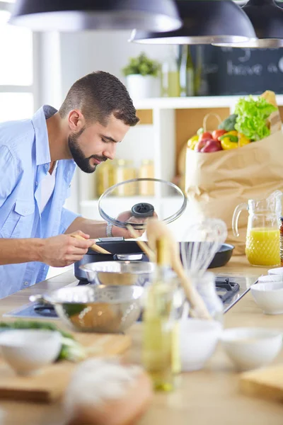 Uomo che prepara cibo delizioso e sano nella cucina di casa — Foto Stock