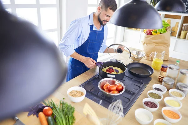 Homem preparando comida deliciosa e saudável na cozinha da casa — Fotografia de Stock