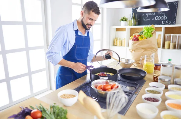 Uomo che prepara cibo delizioso e sano nella cucina di casa — Foto Stock