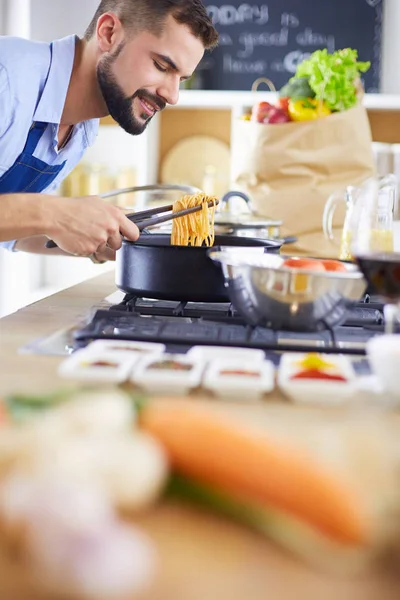 Uomo che prepara cibo delizioso e sano nella cucina di casa — Foto Stock