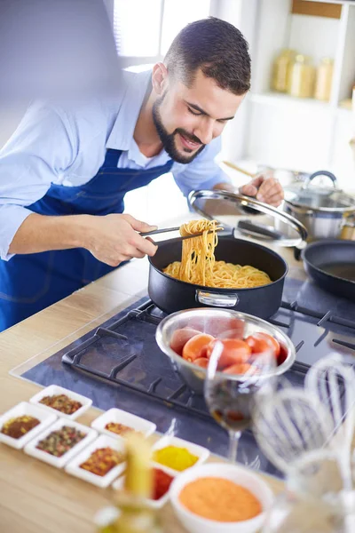 家のキッチンでおいしいと健康食品を準備する男 — ストック写真