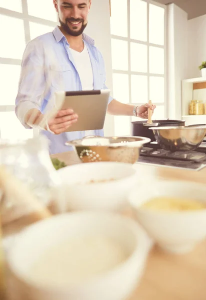 男人们在家里的厨房里按照数码平板电脑的配方烹调美味而健康的食物 — 图库照片