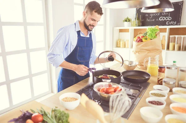 Homem preparando comida deliciosa e saudável na cozinha da casa — Fotografia de Stock