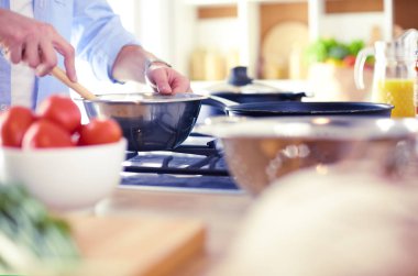 Adam ev mutfağında lezzetli ve sağlıklı yemekler hazırlıyor.