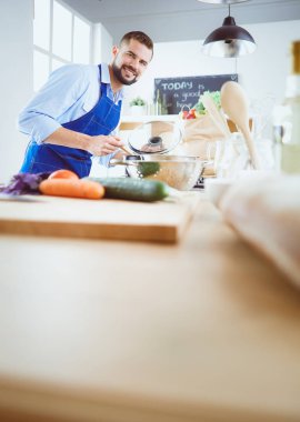 Adam ev mutfağında lezzetli ve sağlıklı yemekler hazırlıyor.