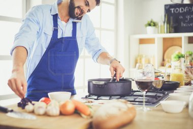 Adam ev mutfağında lezzetli ve sağlıklı yemekler hazırlıyor.