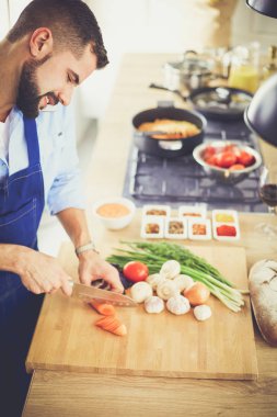 Adam ev mutfağında lezzetli ve sağlıklı yemekler hazırlıyor.