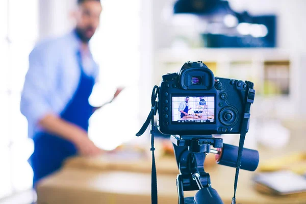 Homem segurando saco de papel cheio de mantimentos no fundo da cozinha. Compras e conceito de comida saudável — Fotografia de Stock