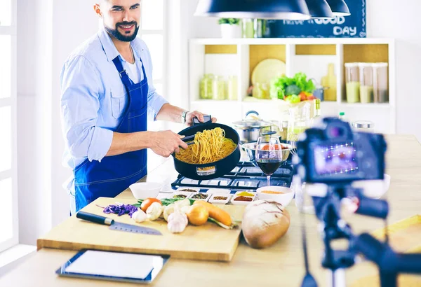 Mann hält Papiertüte voller Lebensmittel auf dem Küchenhintergrund. Shopping und gesundes Ernährungskonzept — Stockfoto