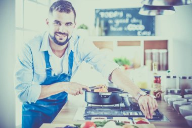 Adam ev mutfağında lezzetli ve sağlıklı yemekler hazırlıyor.