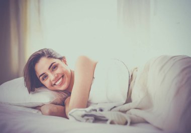Güzel bir kadın yatağında uzanıyor.