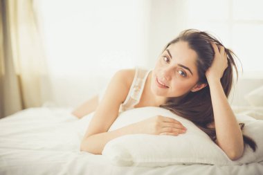 Güzel bir kadın yatağında uzanıyor.