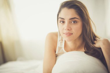 Güzel bir kadın yatağında uzanıyor.