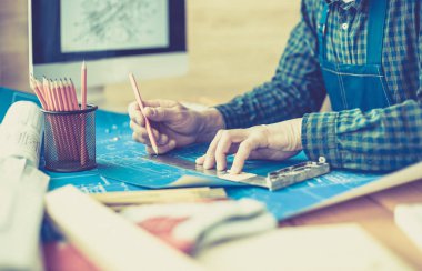 Ofisteki çizim masasında çalışan mimar