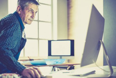 Ofisteki çizim masasında çalışan mimar