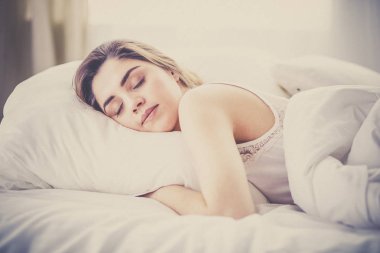 Güzel bir kadın yatağında uzanıyor.