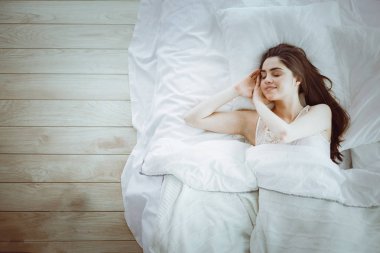 Güzel bir kadın yatağında uzanıyor.