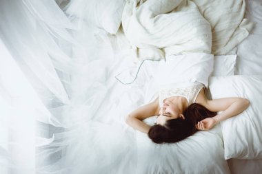 Güzel bir kadın yatağında uzanıyor.