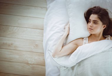 Güzel bir kadın yatağında uzanıyor.