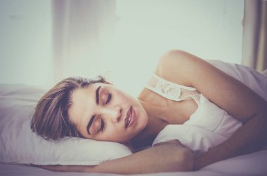 Güzel bir kadın yatağında uzanıyor.