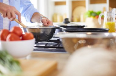 Adam ev mutfağında lezzetli ve sağlıklı yemekler hazırlıyor.