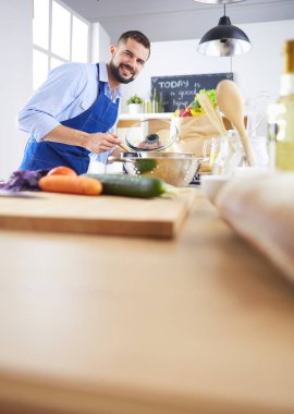 Adam ev mutfağında lezzetli ve sağlıklı yemekler hazırlıyor.