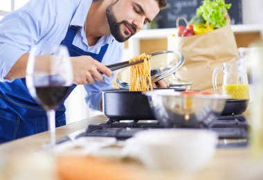 Adam ev mutfağında lezzetli ve sağlıklı yemekler hazırlıyor.