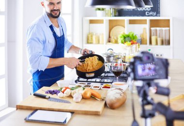Mutfak arka planında poşet dolusu erzak tutan adam. Alışveriş ve sağlıklı gıda konsepti