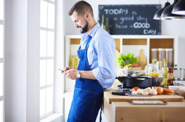 Mutfak arka planında poşet dolusu erzak tutan adam. Alışveriş ve sağlıklı gıda konsepti