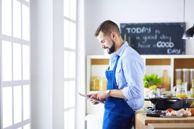 Mutfak arka planında poşet dolusu erzak tutan adam. Alışveriş ve sağlıklı gıda konsepti