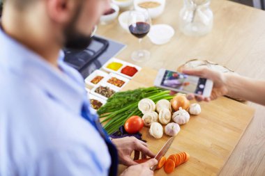 Adam ev mutfağında lezzetli ve sağlıklı yemekler hazırlıyor.