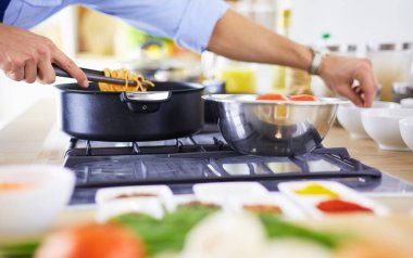 Adam ev mutfağında lezzetli ve sağlıklı yemekler hazırlıyor.