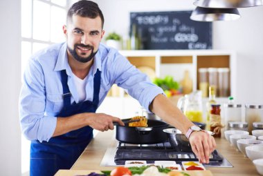 Adam ev mutfağında lezzetli ve sağlıklı yemekler hazırlıyor.