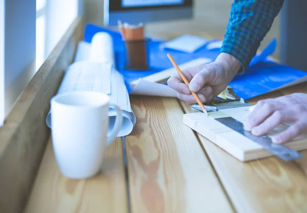 Arquitecto trabajando en mesa de dibujo en la oficina —  Fotos de Stock