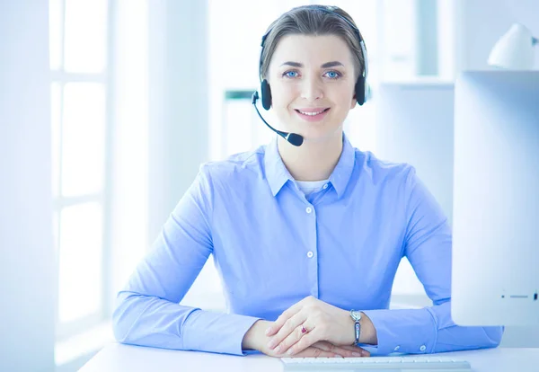 Mujer bastante joven y seria que trabaja como operador de telefonía de apoyo con auriculares en la oficina —  Fotos de Stock